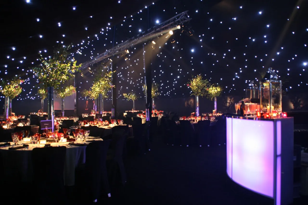 Marquee interior after dark with a starlit ceiling and lit trees